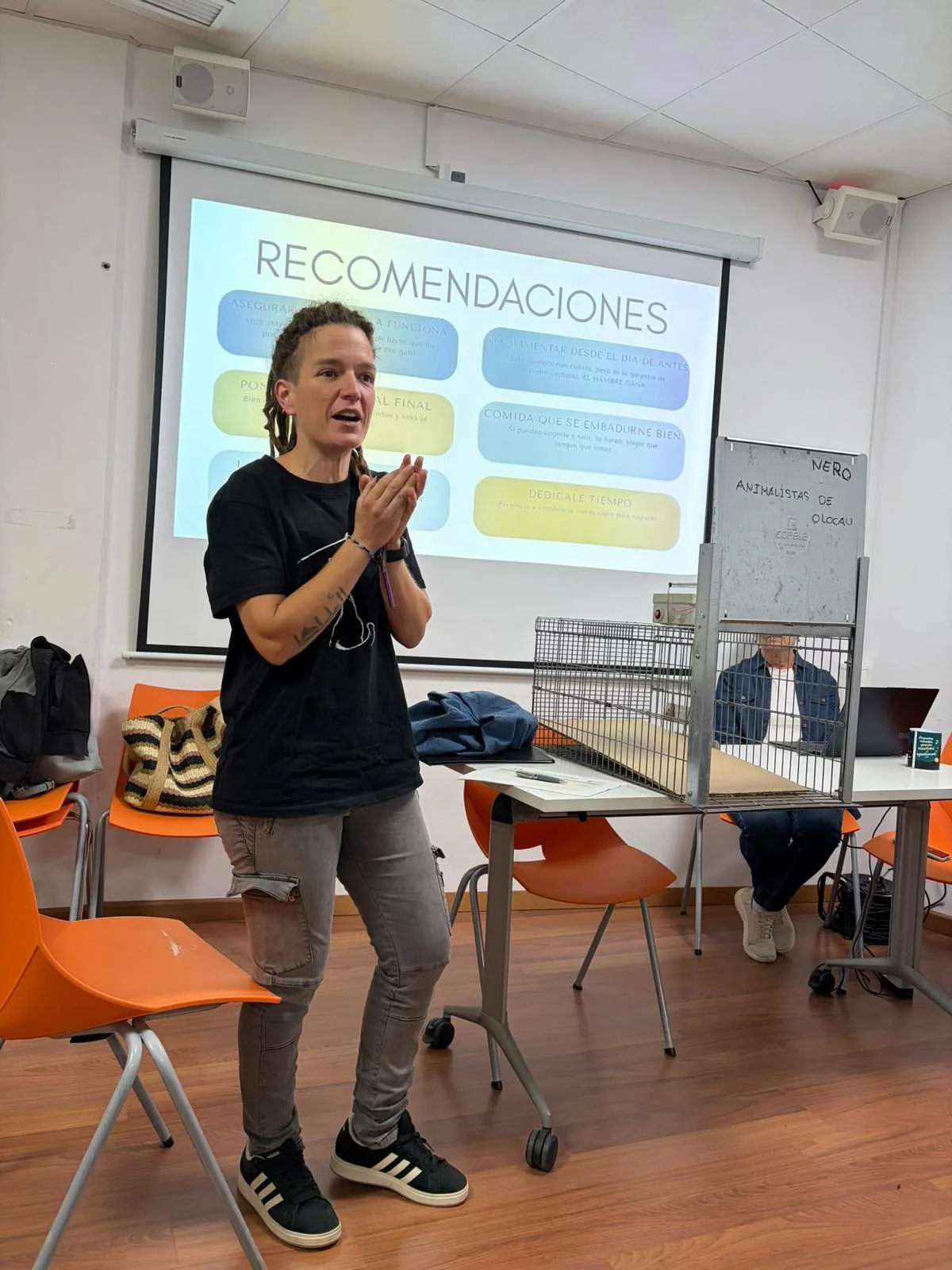 Explicación de las recomendaciones de captura, con una jaula trampa junto a la ponente